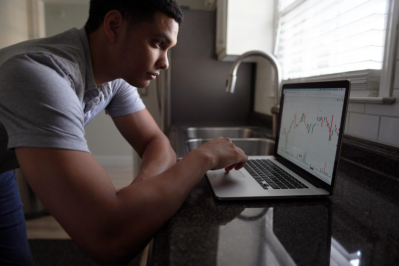 An investor looking at a laptop - he is in analysis paralysis